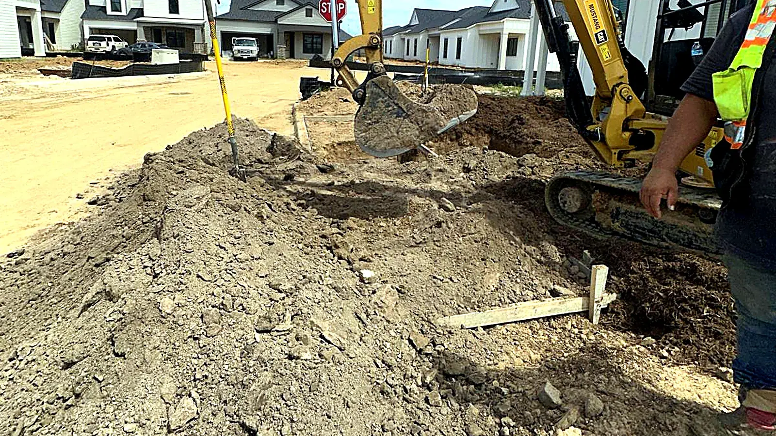 Excavator opening a trench for conduit