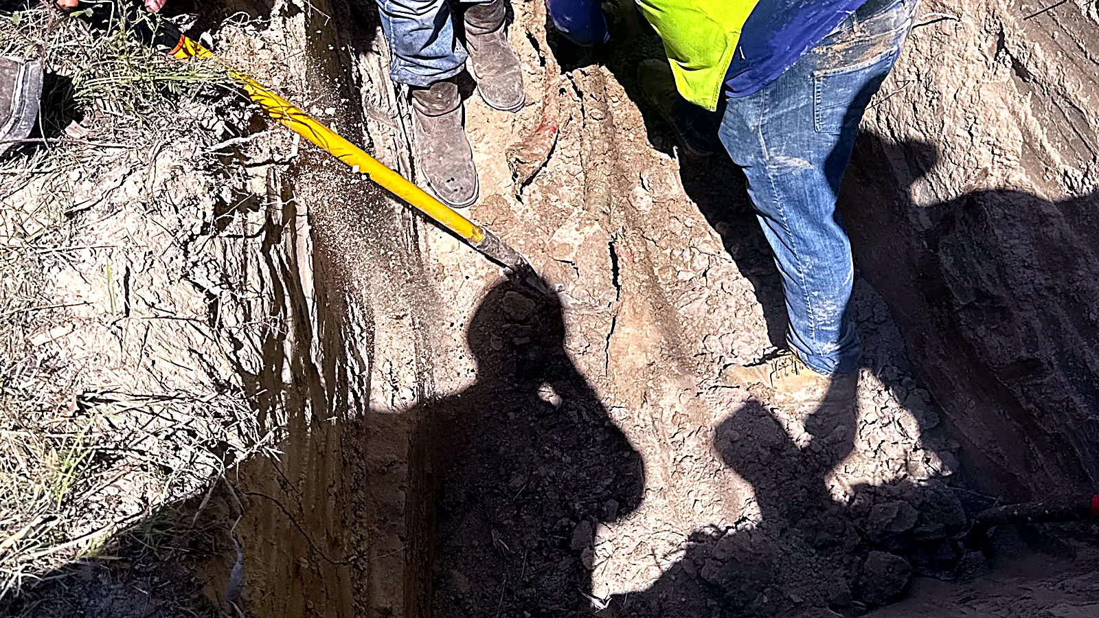 Crew placing conduit in a trench